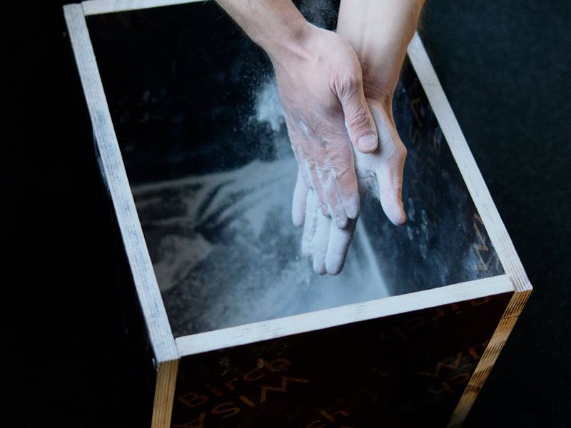 Close-up of gym equipment and a man hands preparing for exercise.